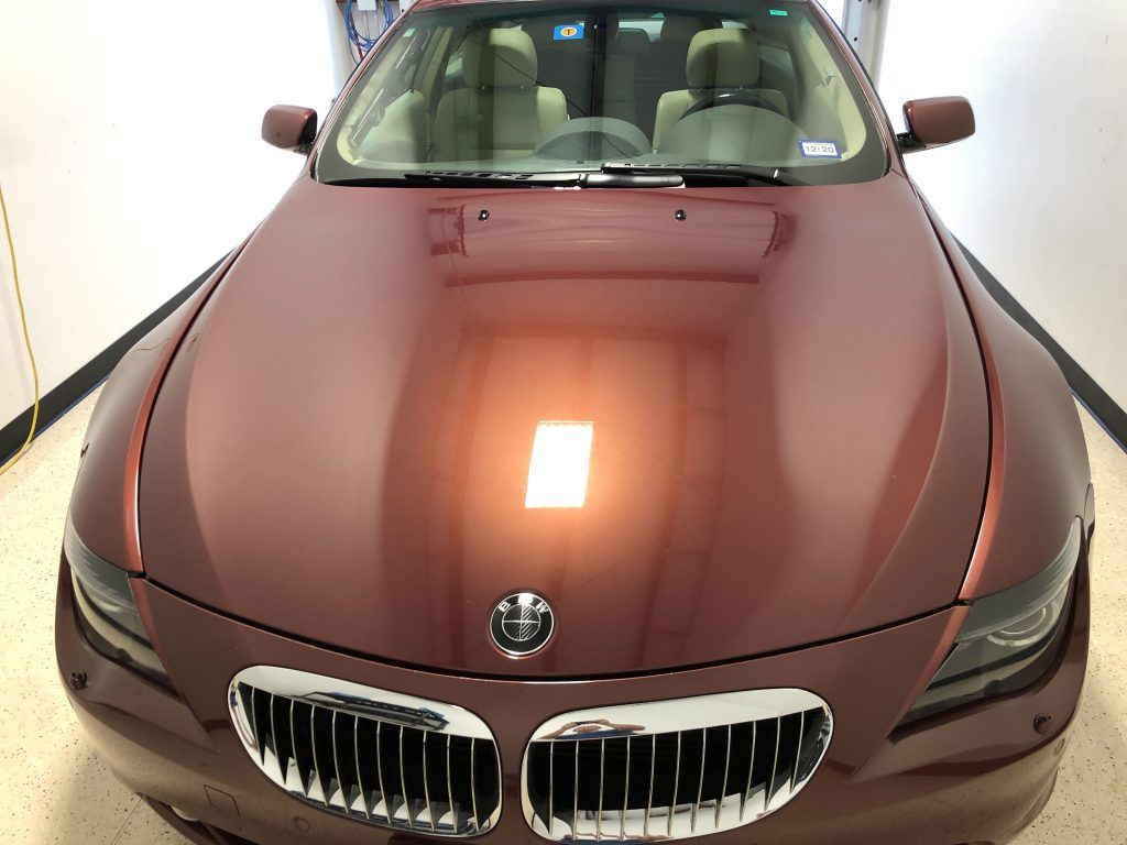 A red bmw is parked in a garage.