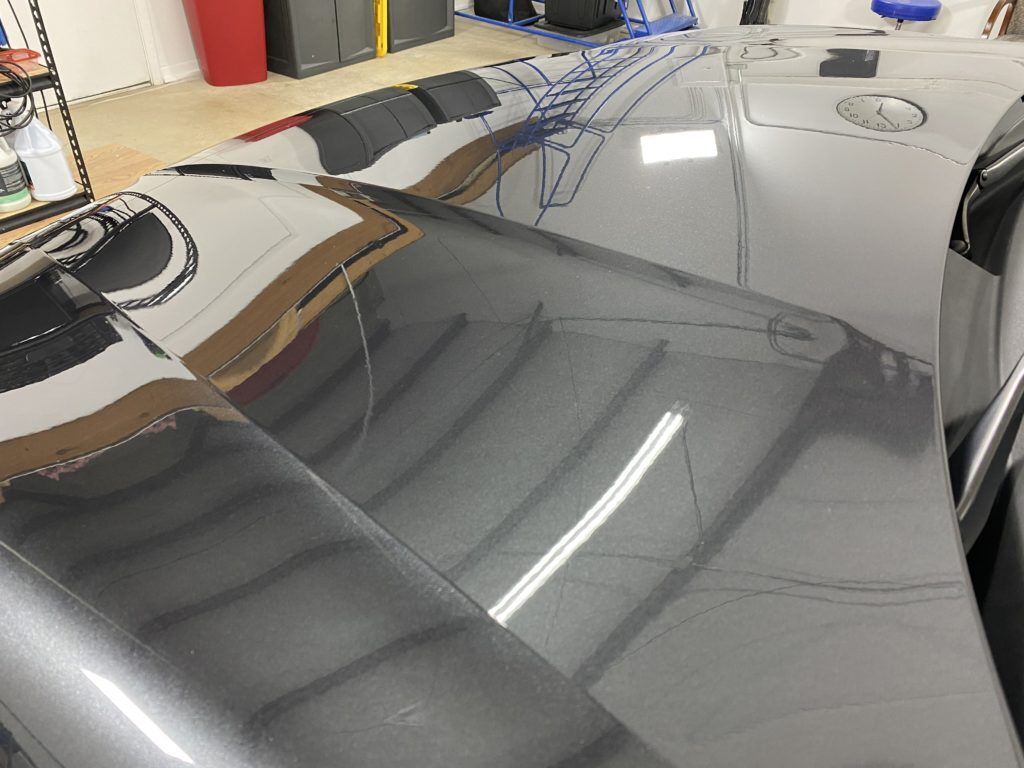 A close up of the hood of a car in a garage.