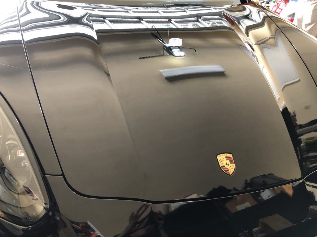 A black porsche 911 is parked in a garage.