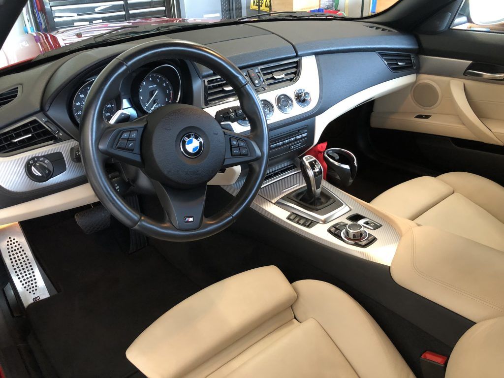 The interior of a red bmw z4 convertible is shown.
