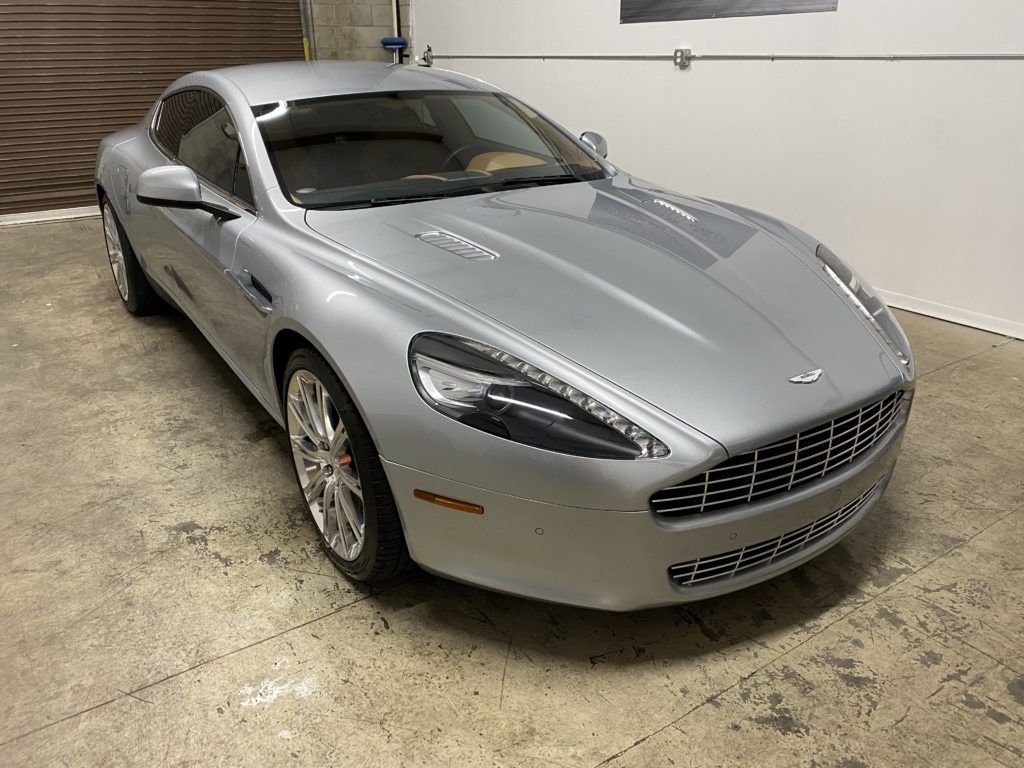 A silver sports car is parked in a garage.