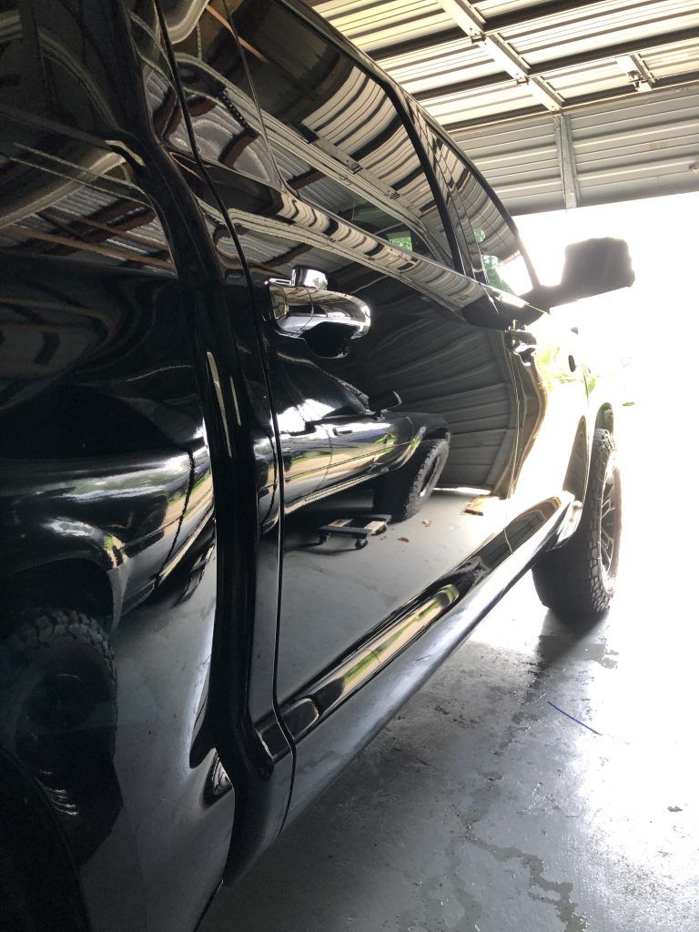 A black car is parked in a garage.