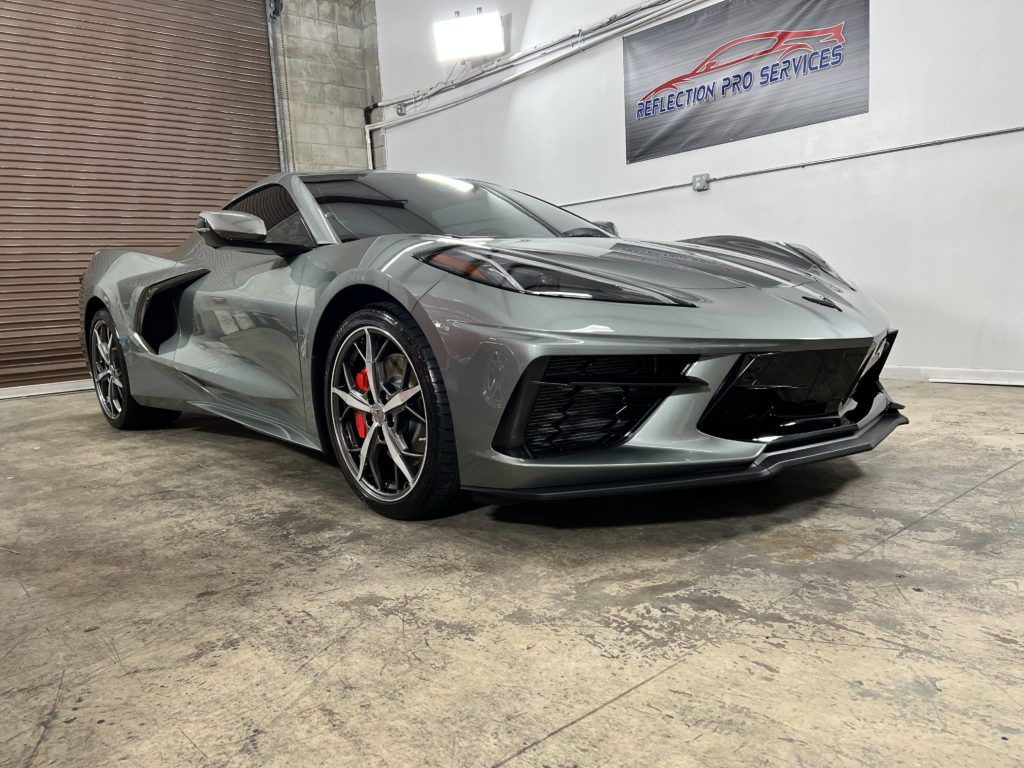 A gray sports car is parked in a garage.