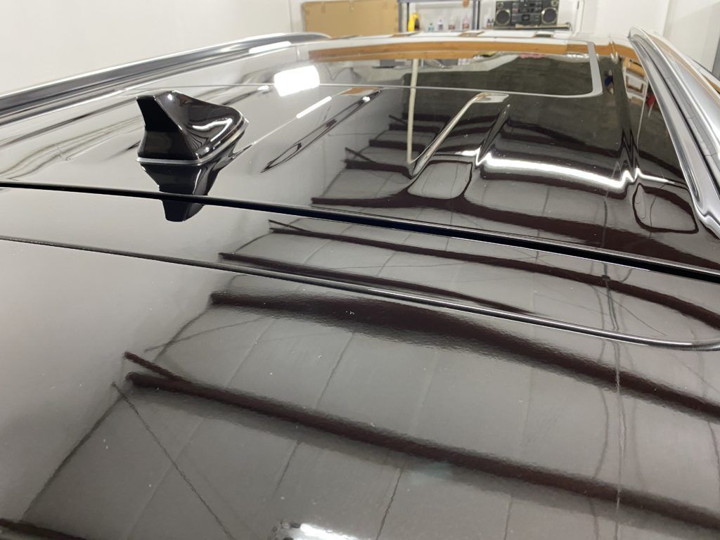 The roof of a car is reflected in a mirror.