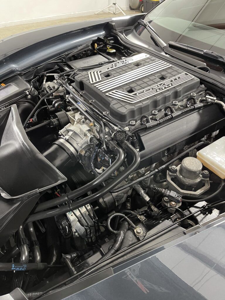 A close up of a car engine with the hood open.