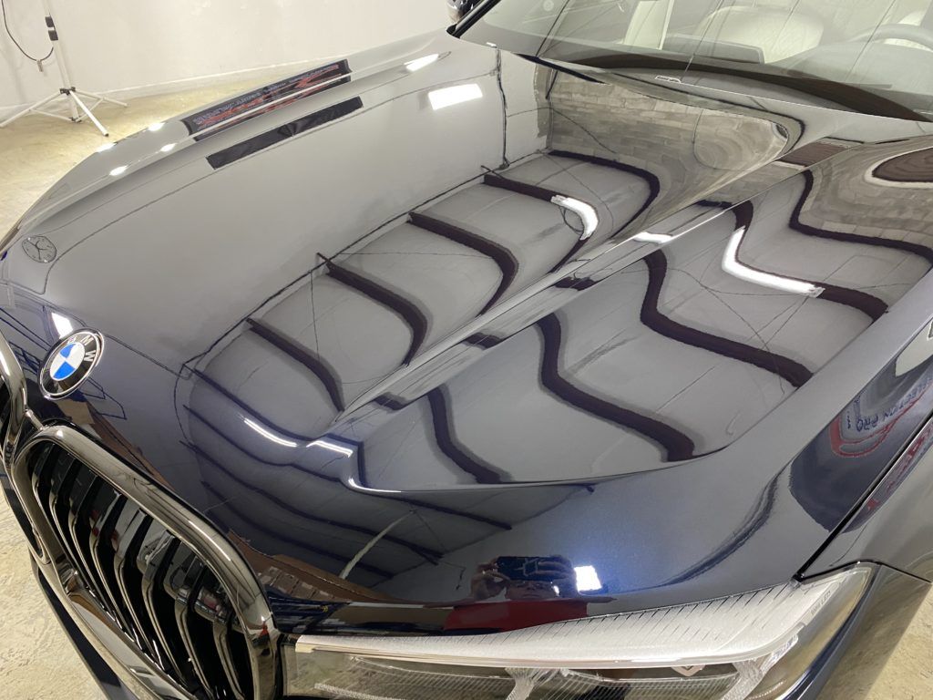 A close up of the hood of a bmw x5 in a garage.