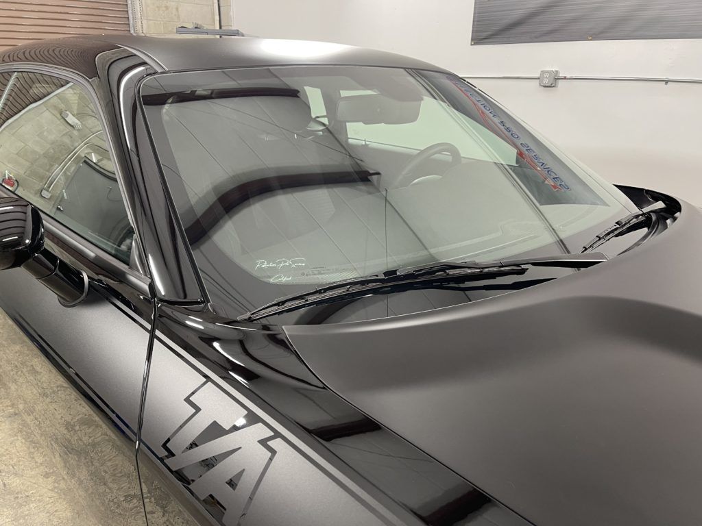 A black car with the word tax on the side is parked in a garage.