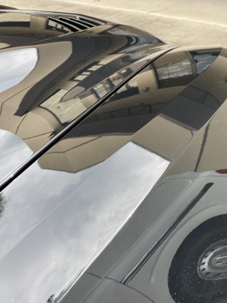 A close up of a car windshield with a reflection of a plane