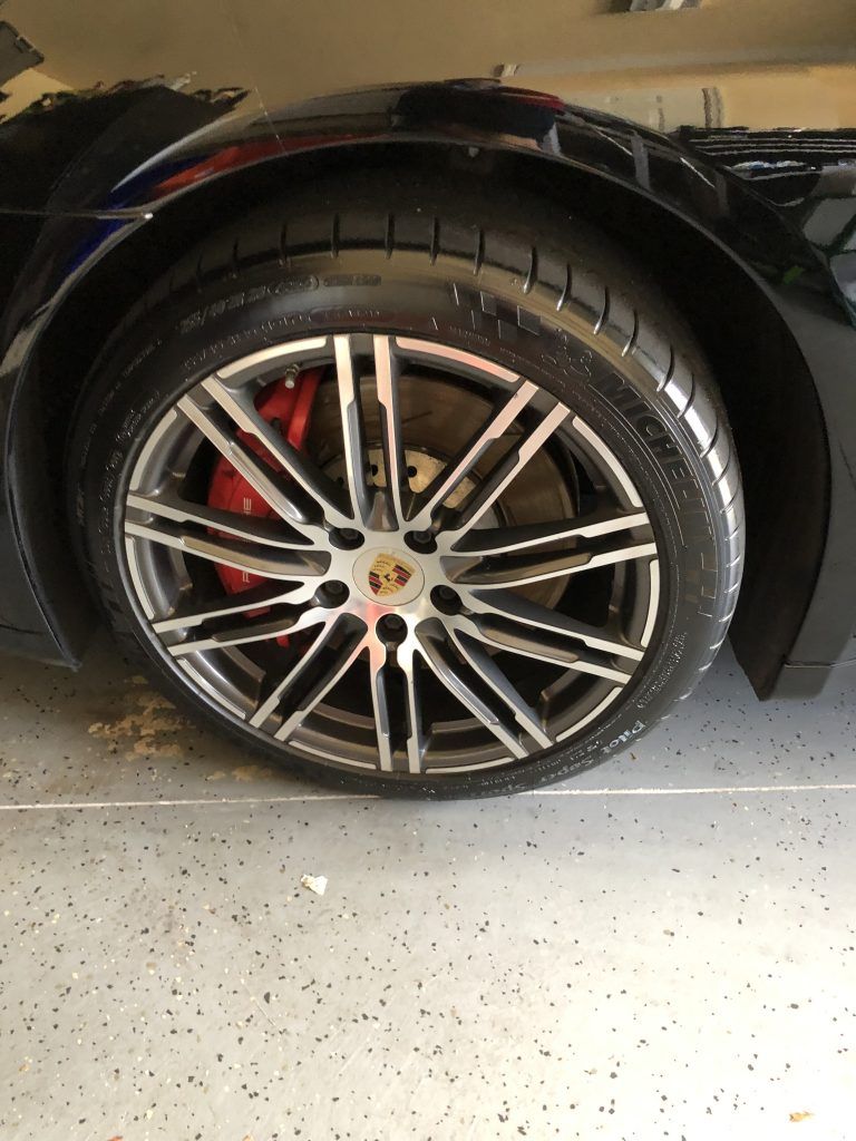 A close up of a car wheel in a garage.