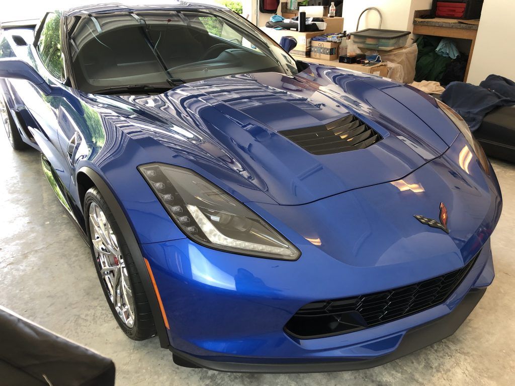 A blue sports car is parked in a garage.