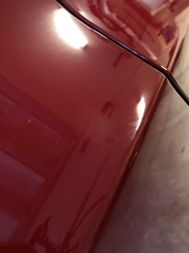 A close up of a red car in a garage