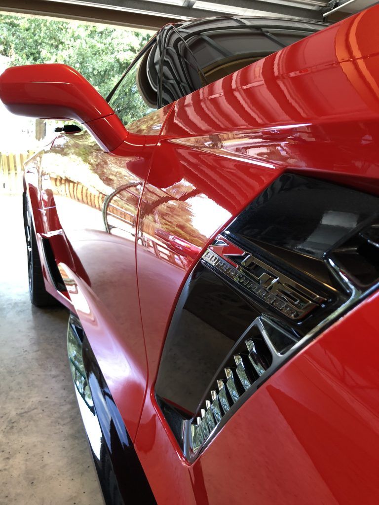 A red sports car is parked in a garage.
