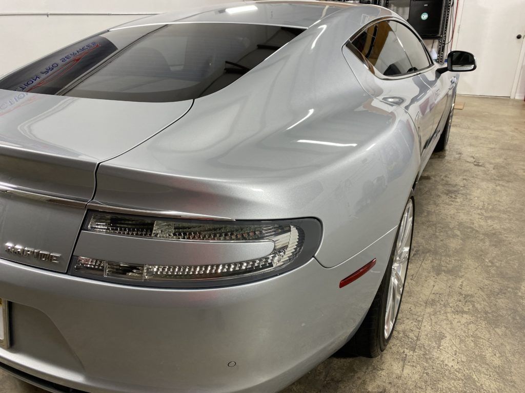 A silver sports car is parked in a garage.