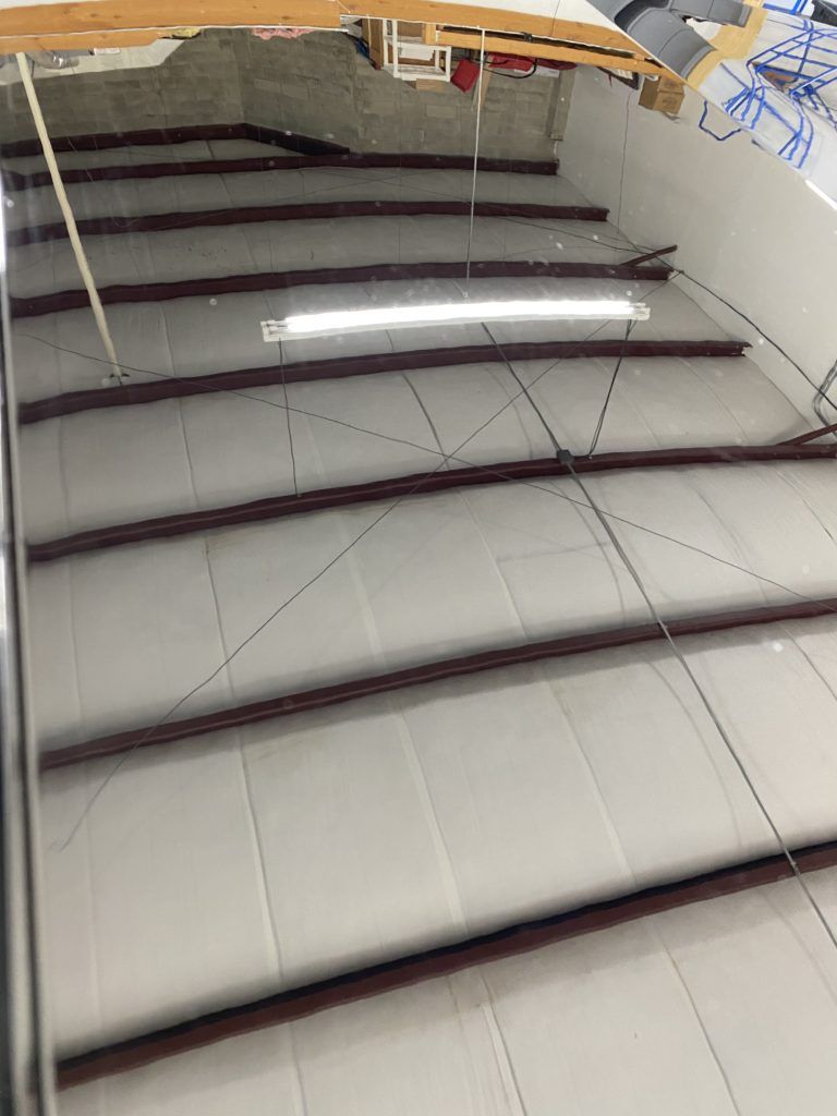 A ceiling with a lot of wooden beams and a light hanging from it.