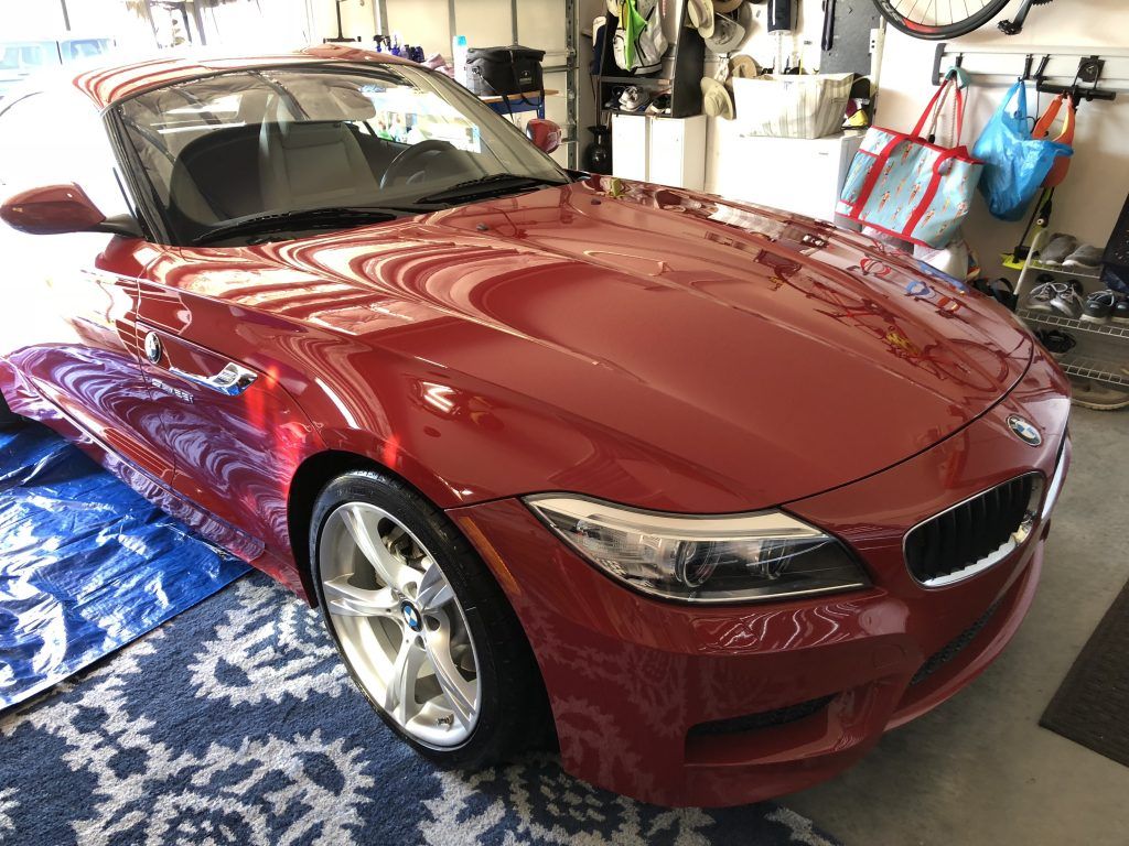 A red bmw z4 is parked in a garage.