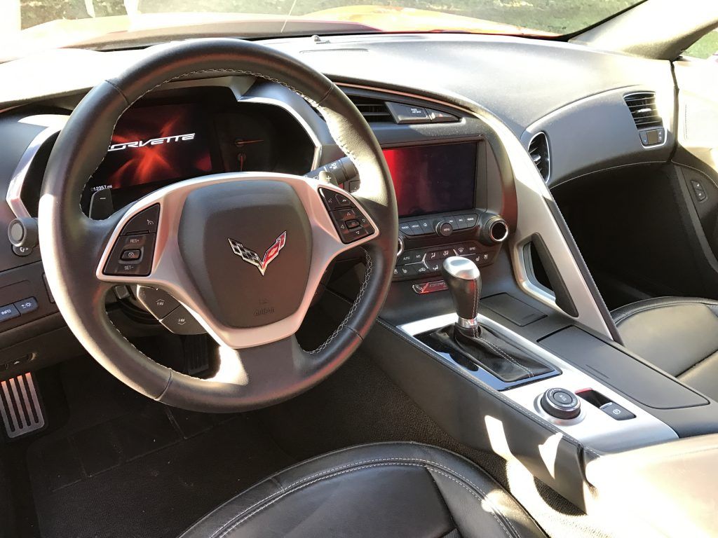 A close up of the steering wheel and dashboard of a corvette.