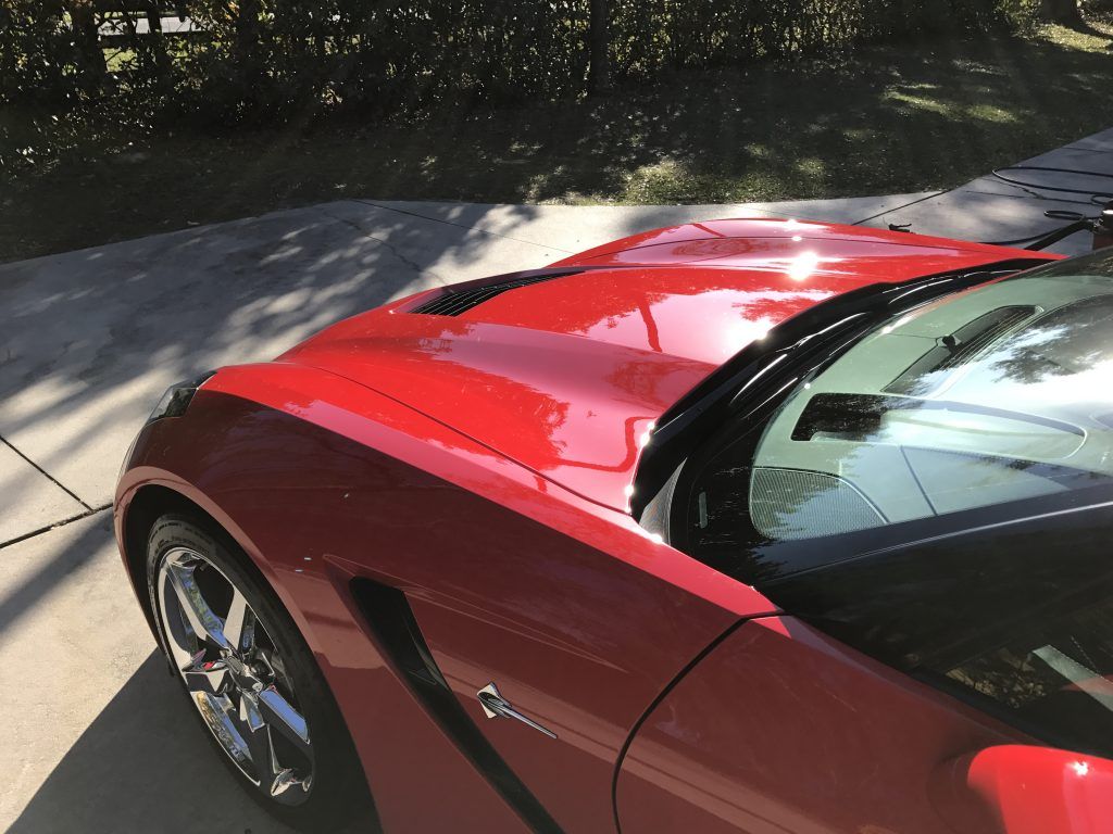 A red sports car is parked on the side of the road