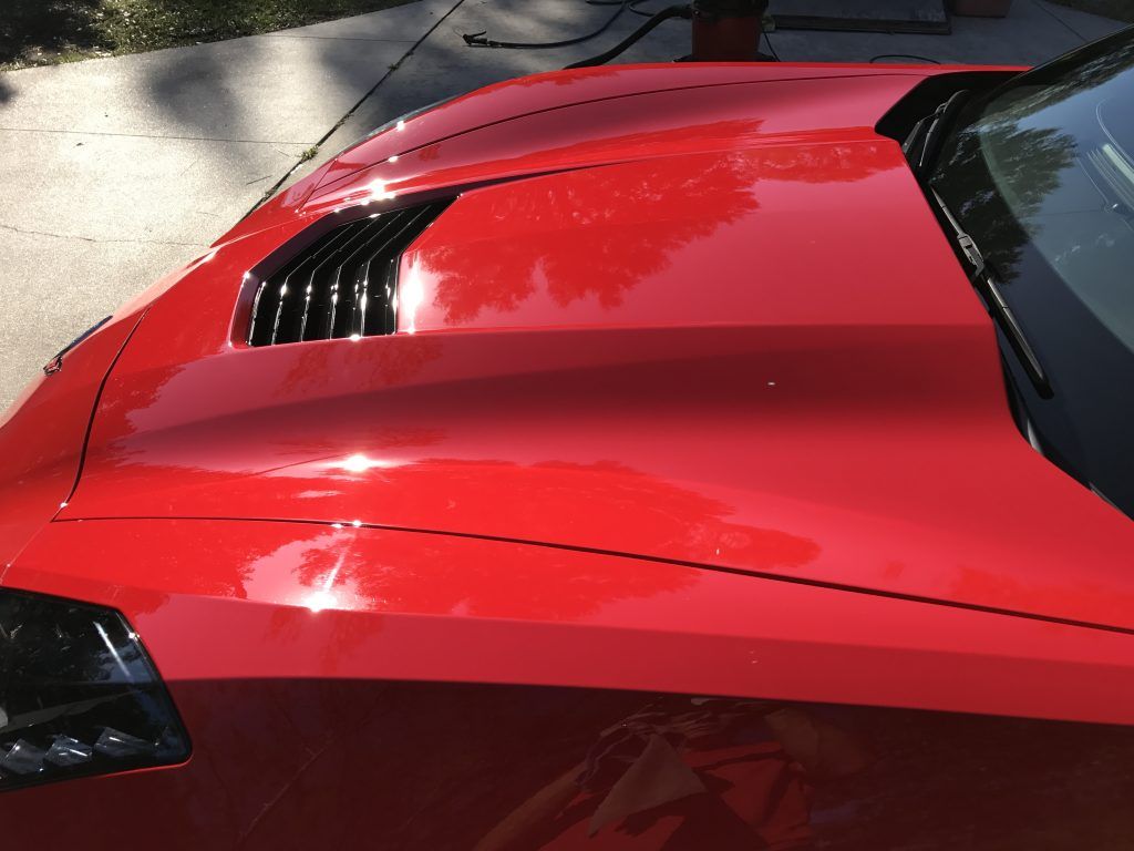 A red sports car is parked on the side of the road