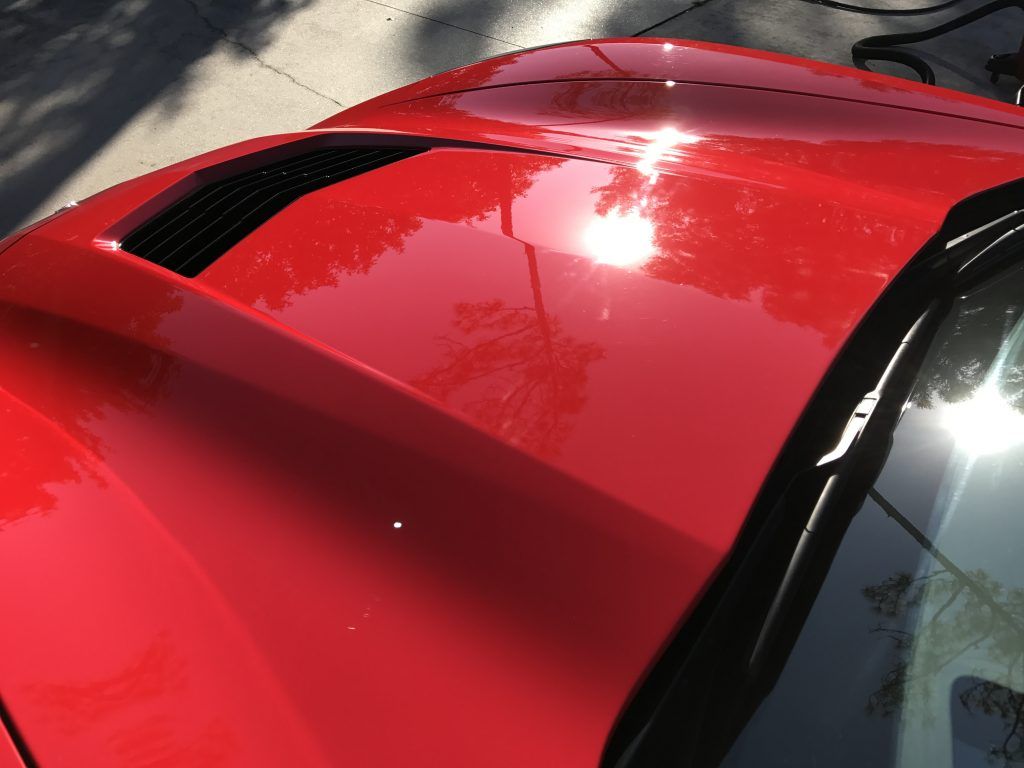 A red car is parked on the side of the road