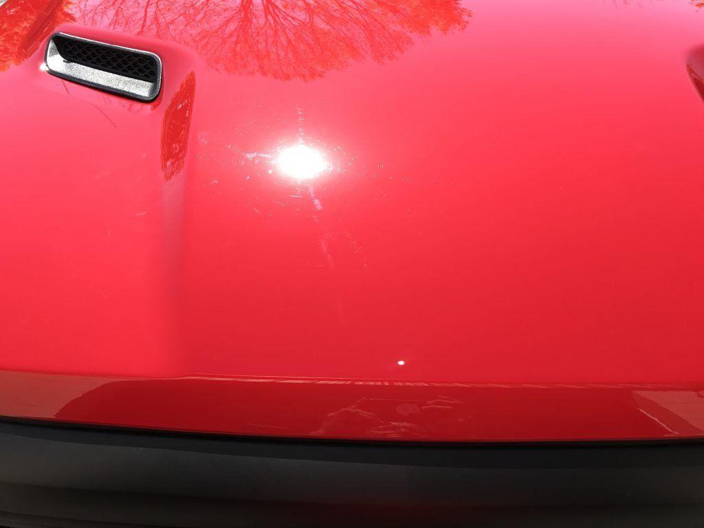 A close up of the hood of a red car