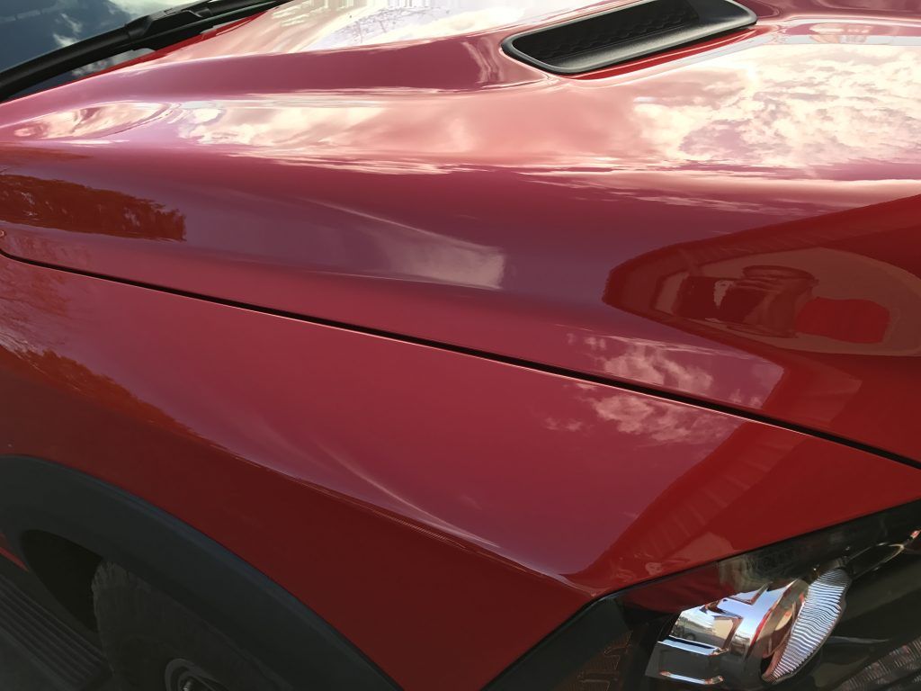 A close up of the hood of a red car