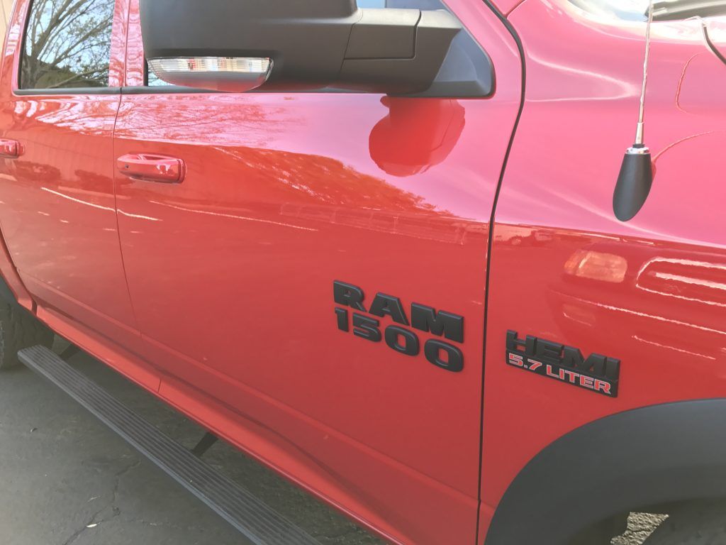 A red ram 1500 truck is parked on the side of the road
