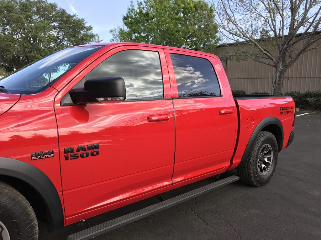 A red ram truck is parked in a parking lot.