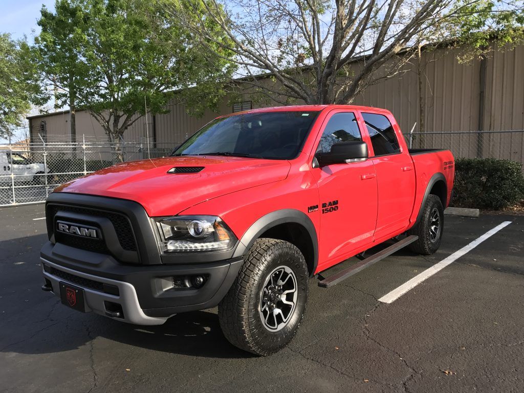 A red ram truck is parked in a parking lot.