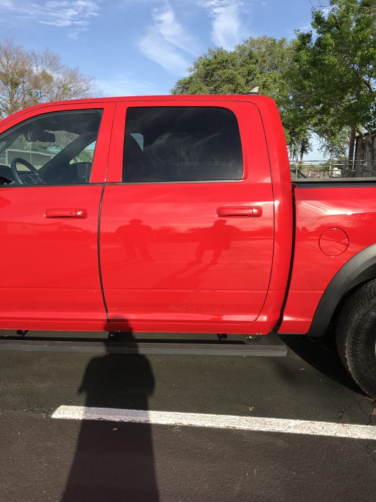 A red truck is parked in a parking lot.