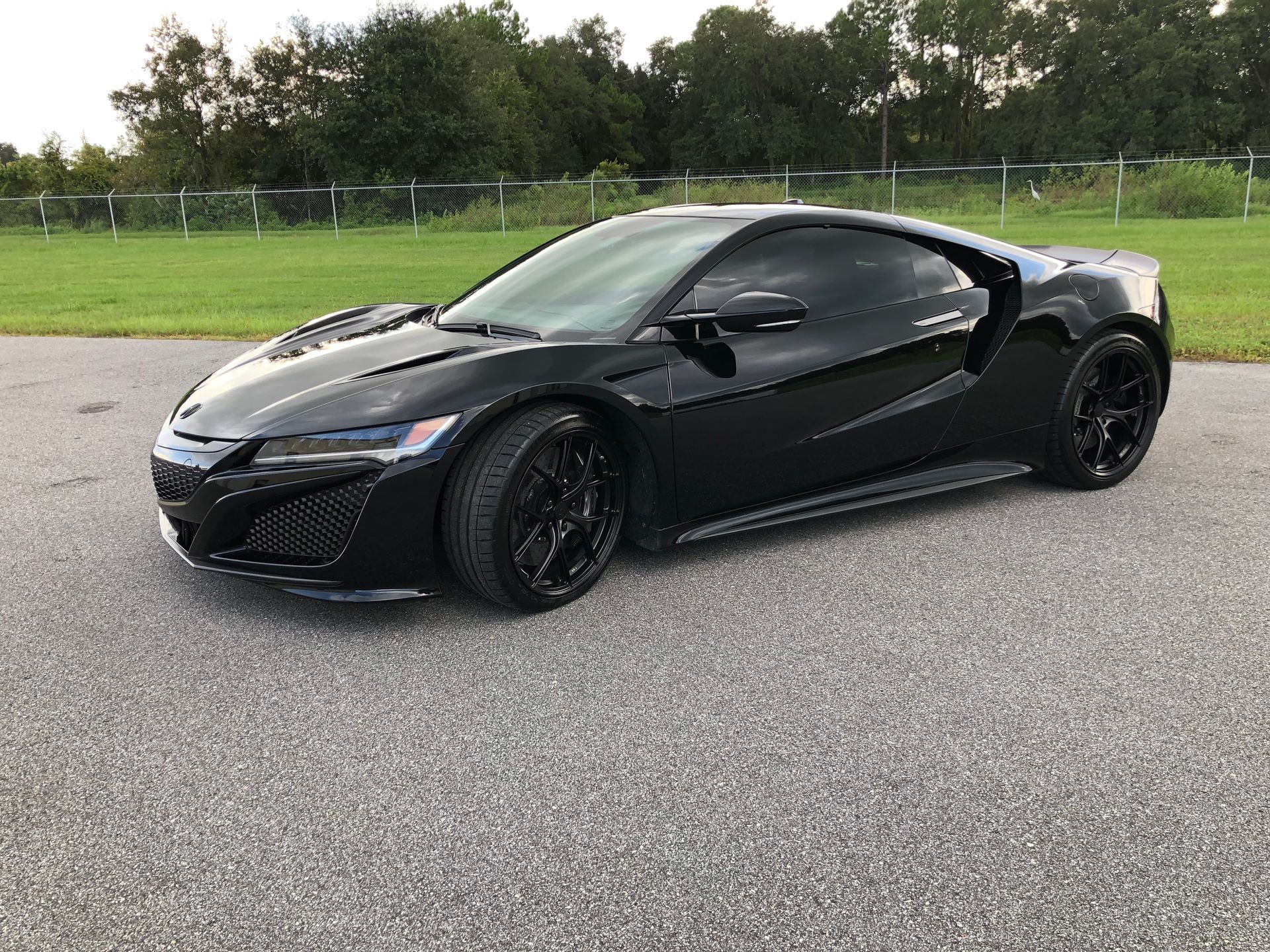 A black sports car is parked on the side of the road.