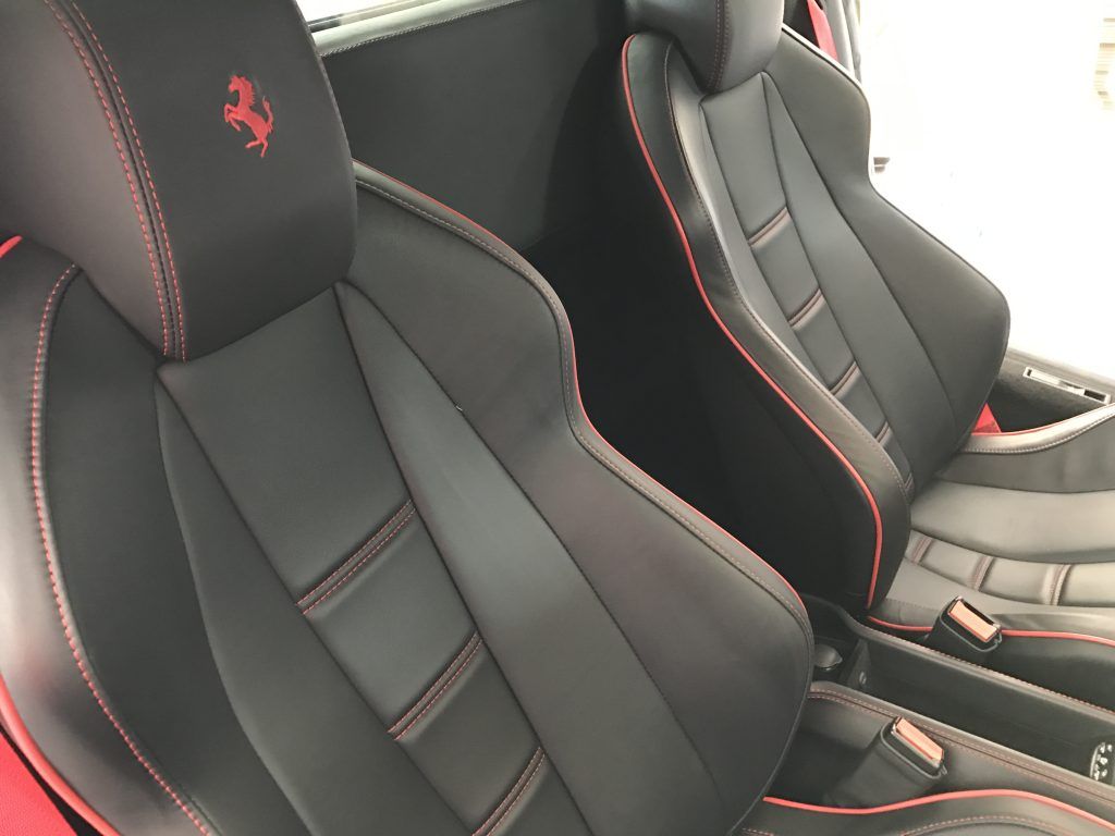 The seats of a ferrari sports car are black and red