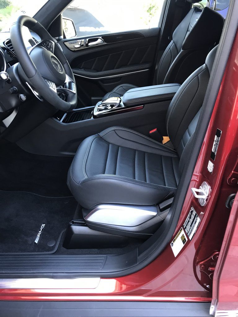 The inside of a red mercedes benz gl63 amg with the door open.
