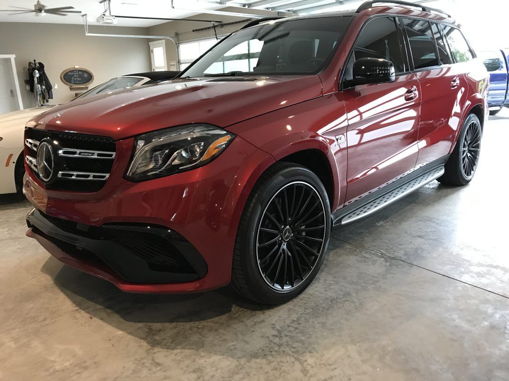 A red mercedes benz gls 63 amg is parked in a garage.