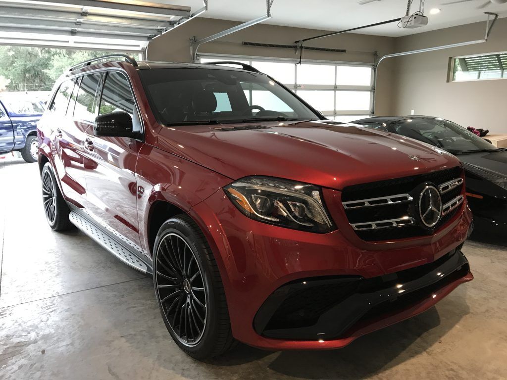 A red mercedes benz gls 63 amg is parked in a garage.