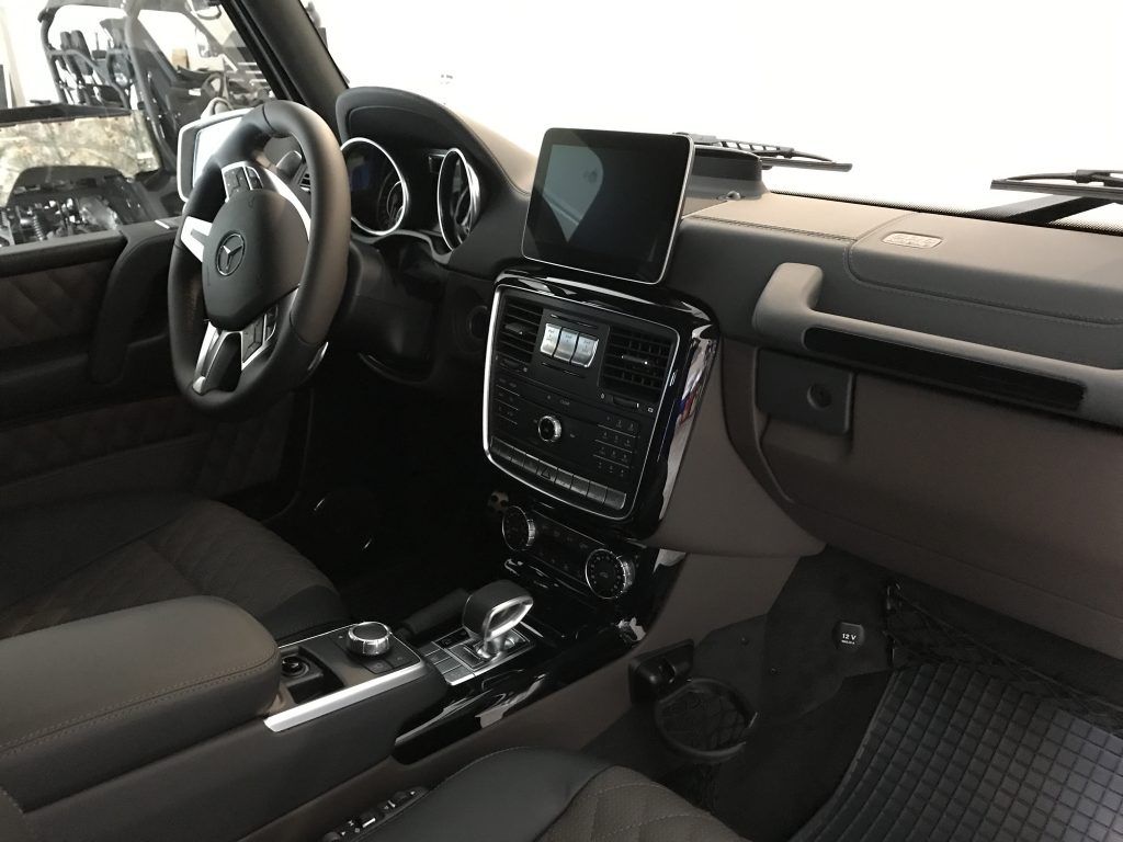 The interior of a car with a tablet on the dashboard.