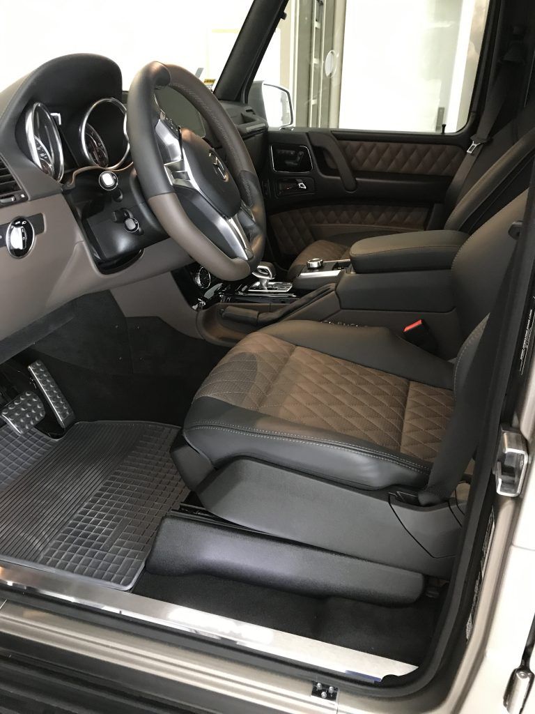 The interior of a mercedes benz g class is shown with the door open.