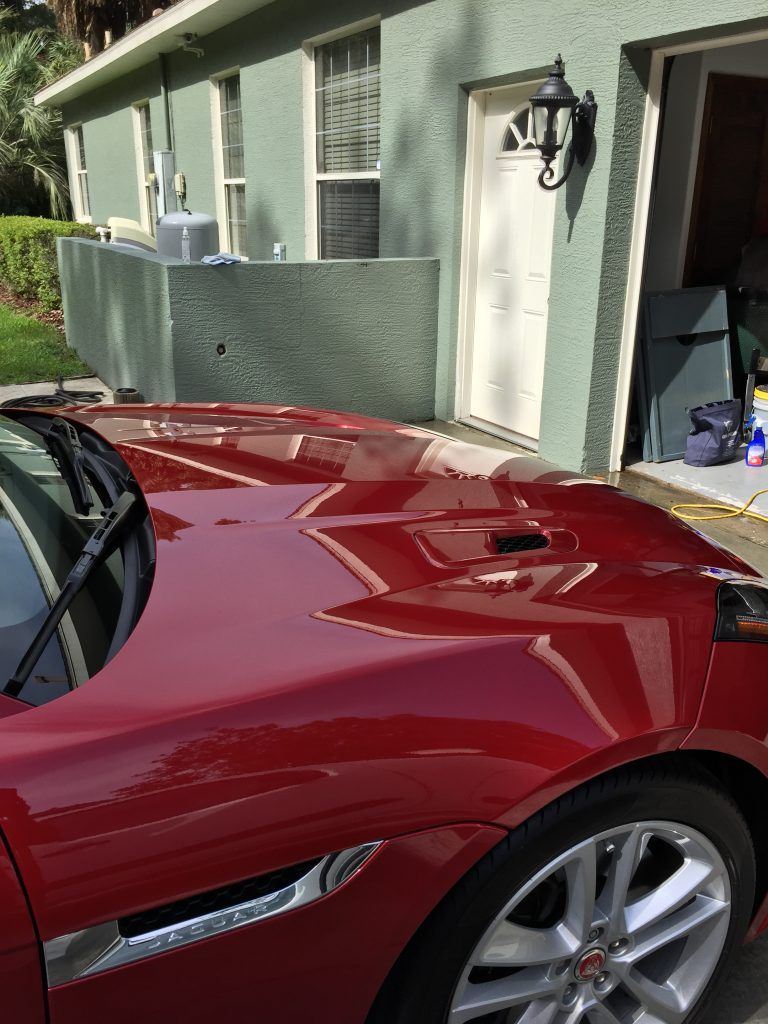 A red sports car is parked in front of a house.