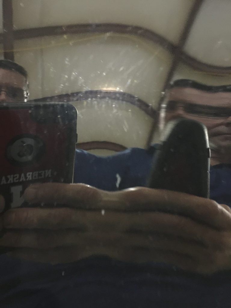 A man is taking a picture of himself in a mirror while using a laptop