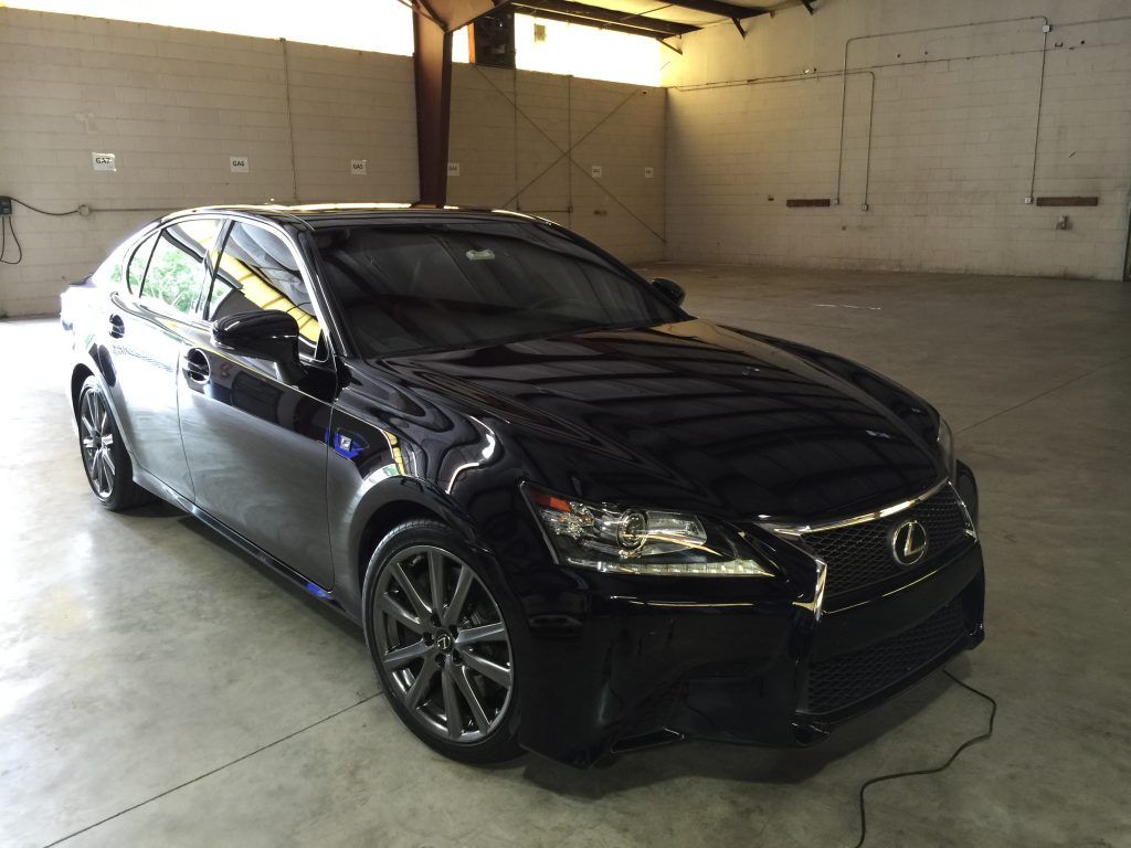 A black lexus car is parked in a garage