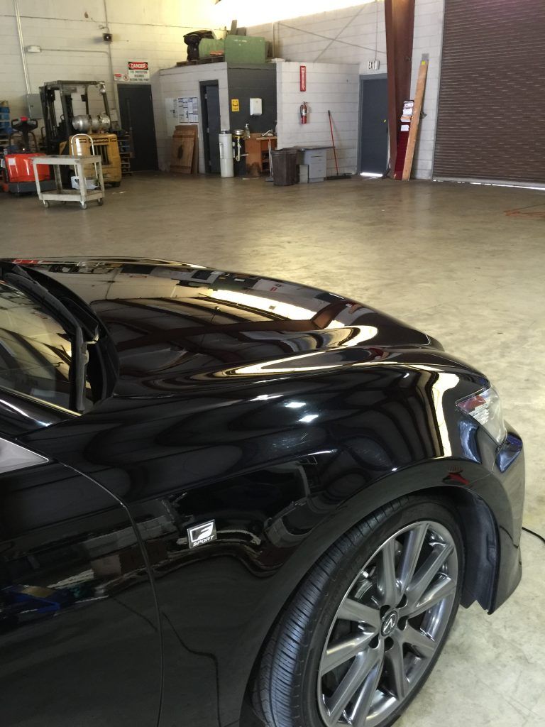 A black car is parked in a garage.