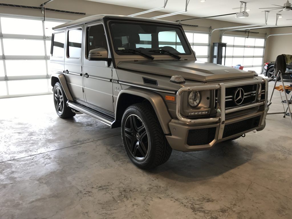A silver mercedes benz g63 amg is parked in a garage.