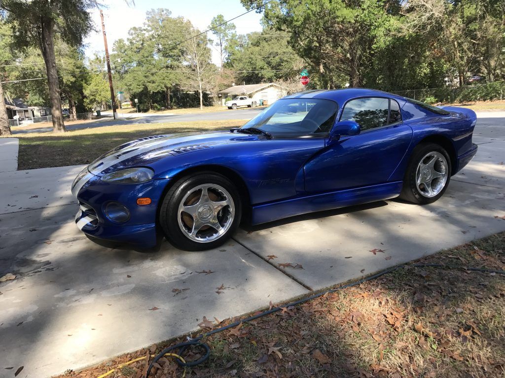 A blue dodge viper is parked on the side of the road.