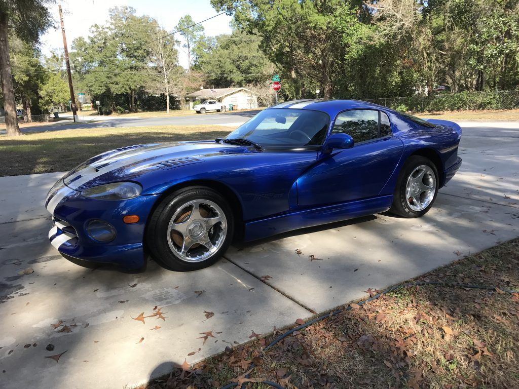 A blue dodge viper is parked on the side of the road.
