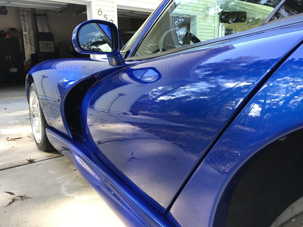A blue sports car is parked in a garage.