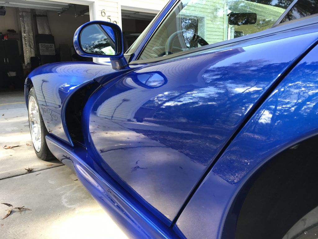 A blue sports car is parked in a garage.