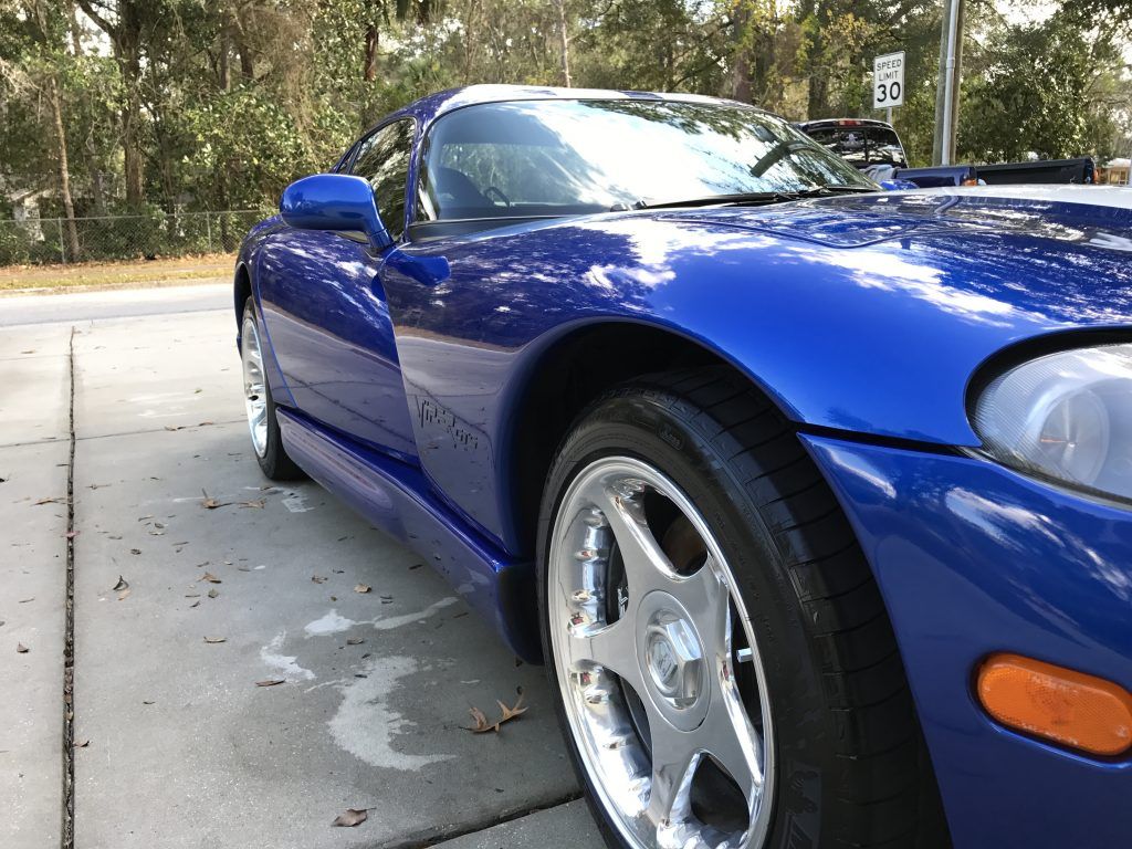 A blue sports car is parked on the side of the road.