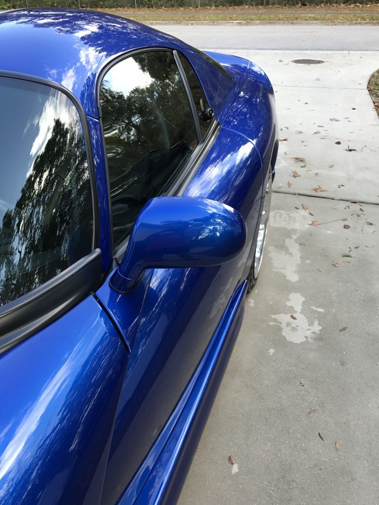 A blue sports car is parked on the side of the road