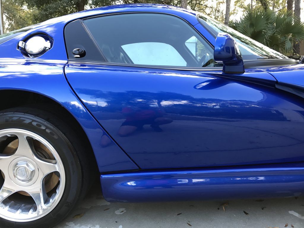 A blue sports car is parked in a parking lot