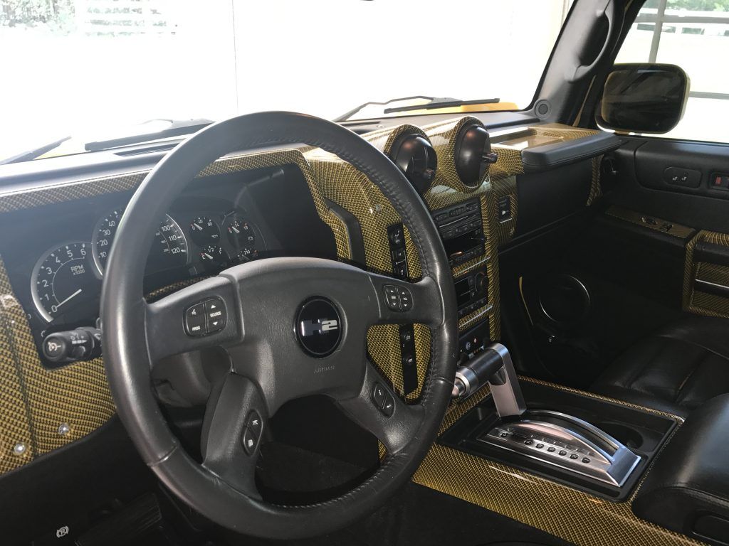 The interior of a hummer h2 with a black steering wheel