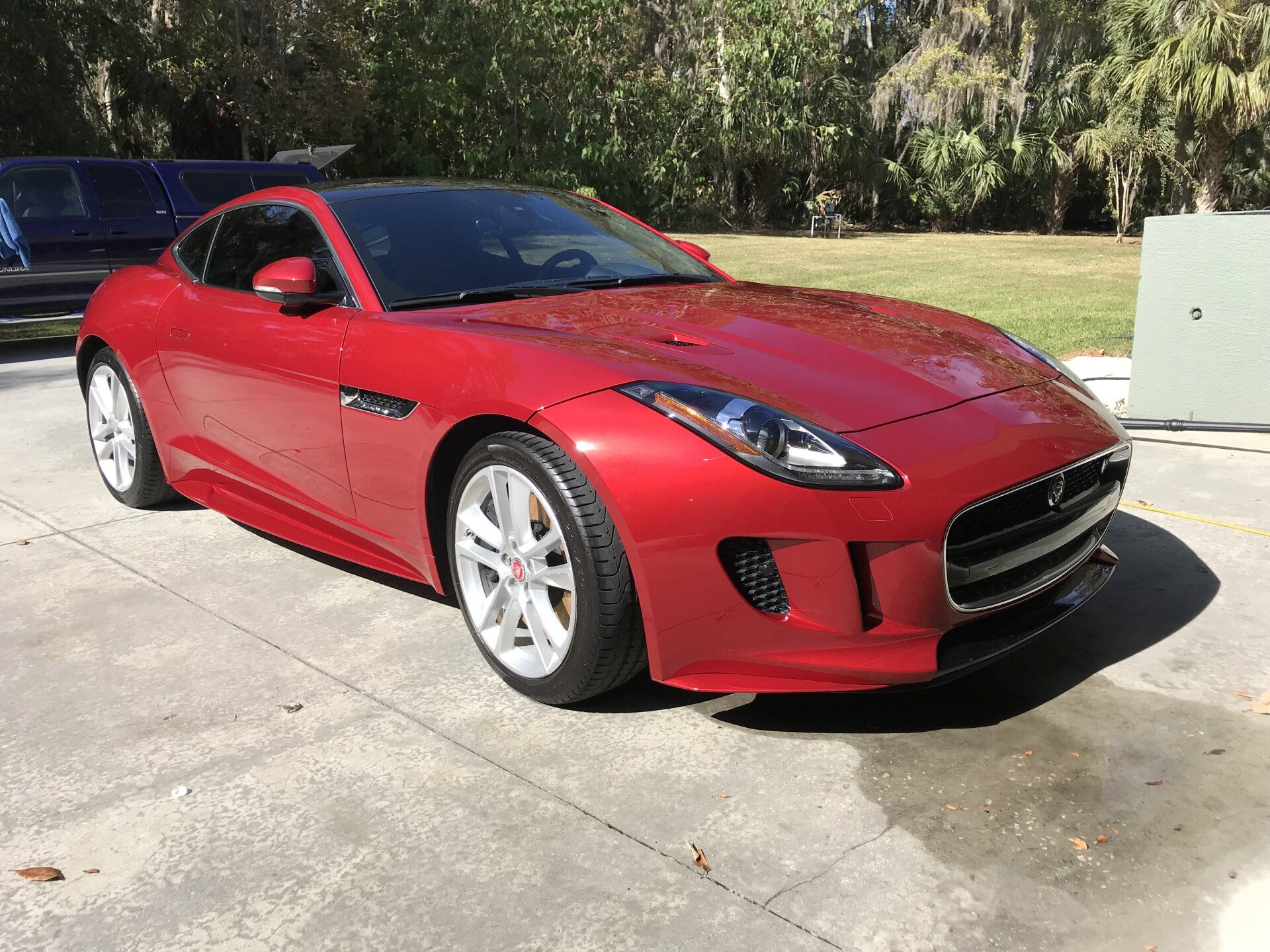 A red jaguar f type is parked in a parking lot.